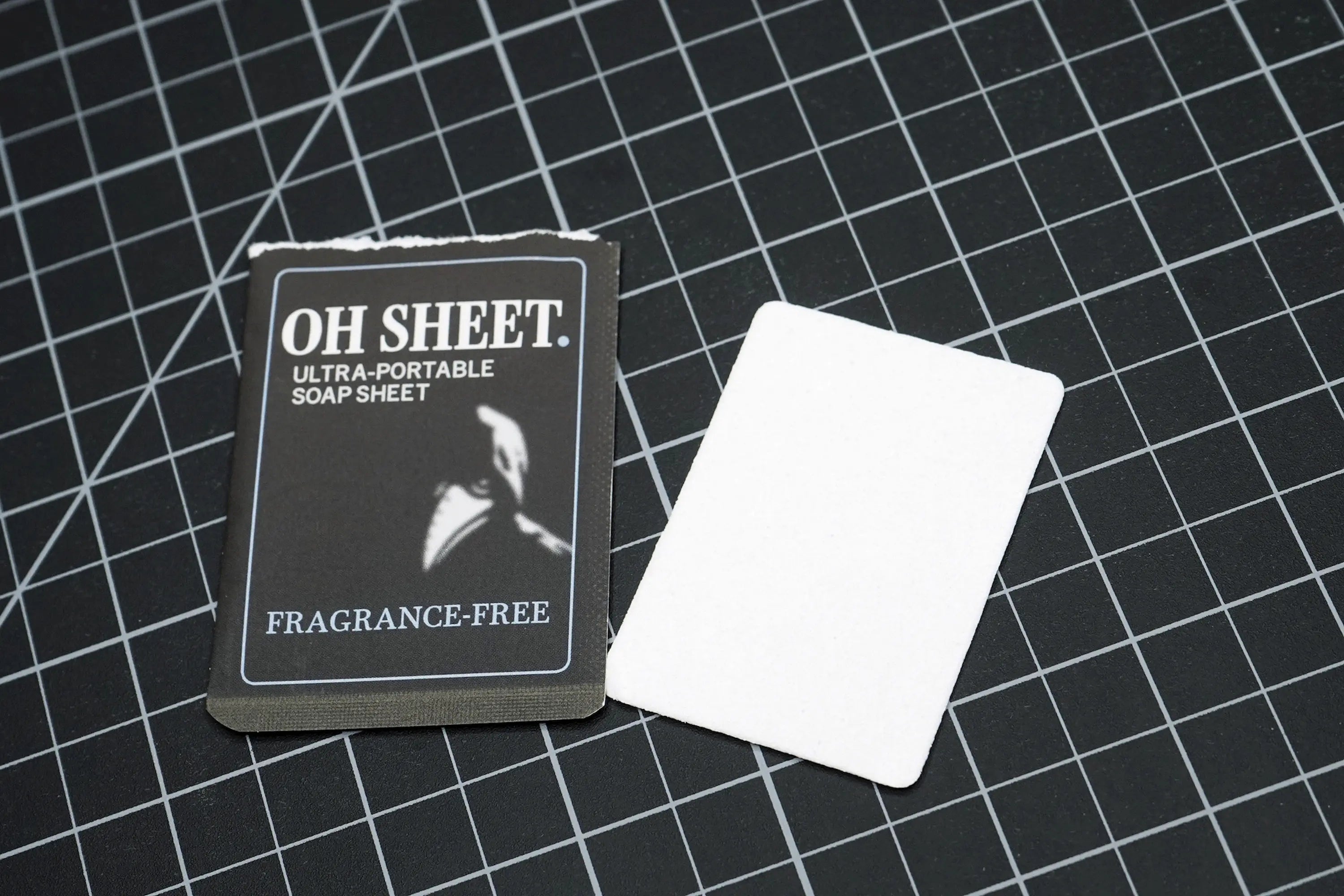 Single use fragrance free paper soap sheet beside sachet